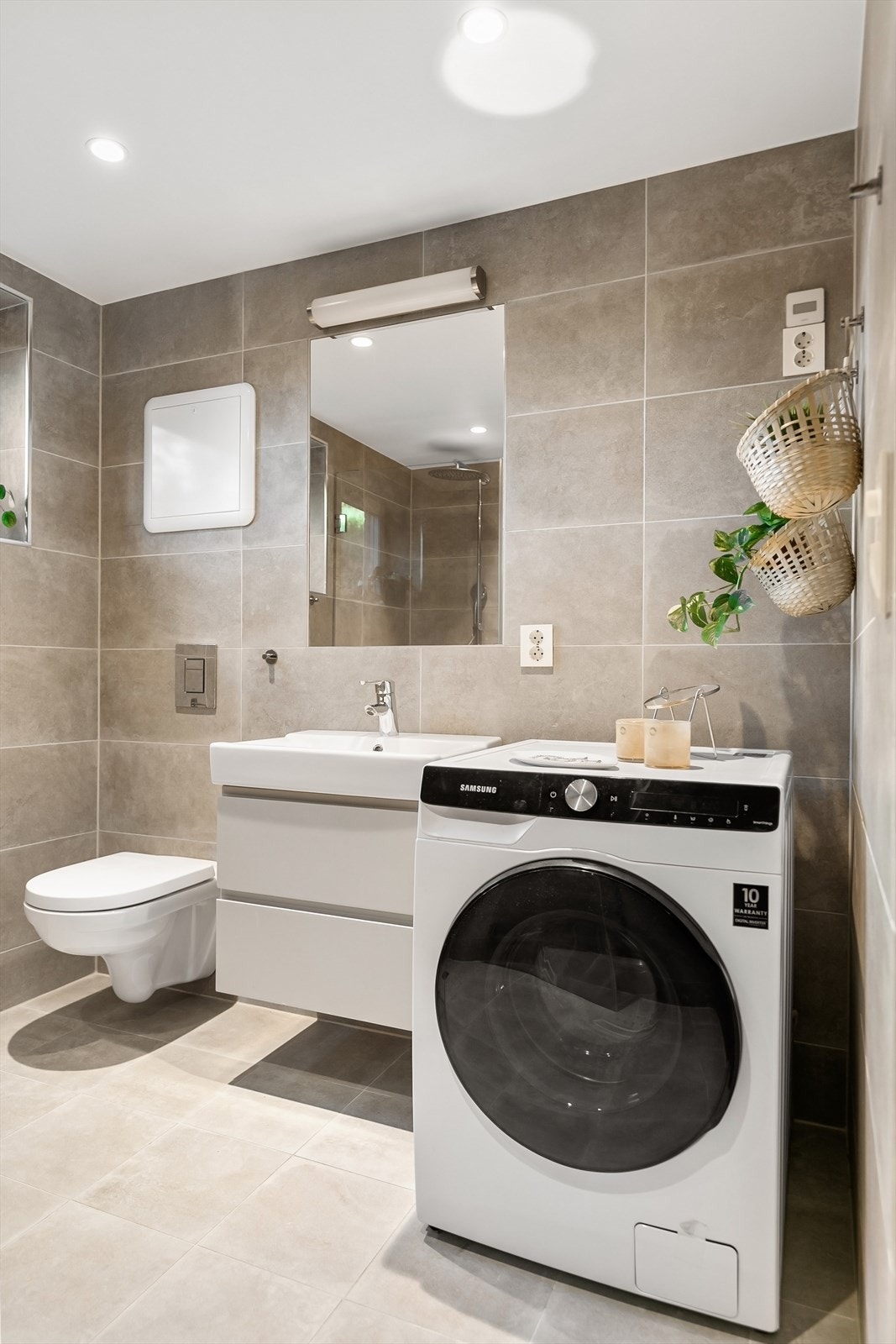 Badet er utstyrt med innredning, speil, klosett, dusj med innfellbare dører og opplegg for vaskemaskin. Galleribilde