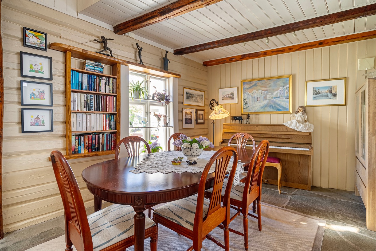 I spisestuen er hyller elegant bygget inn i tømmerveggen og harmonerer flott med de synlige dragerne i taket Galleribilde