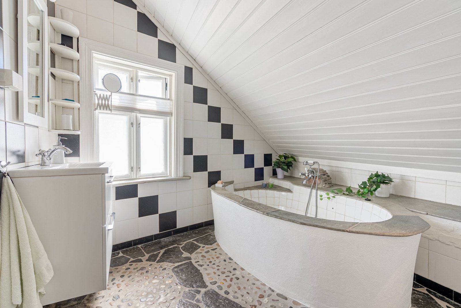 Her møtes særpreg og modernitet på en fin måte, med karakterfulle detaljer i gulv og badekar kombinert med mer moderne fliser og innredning Galleribilde