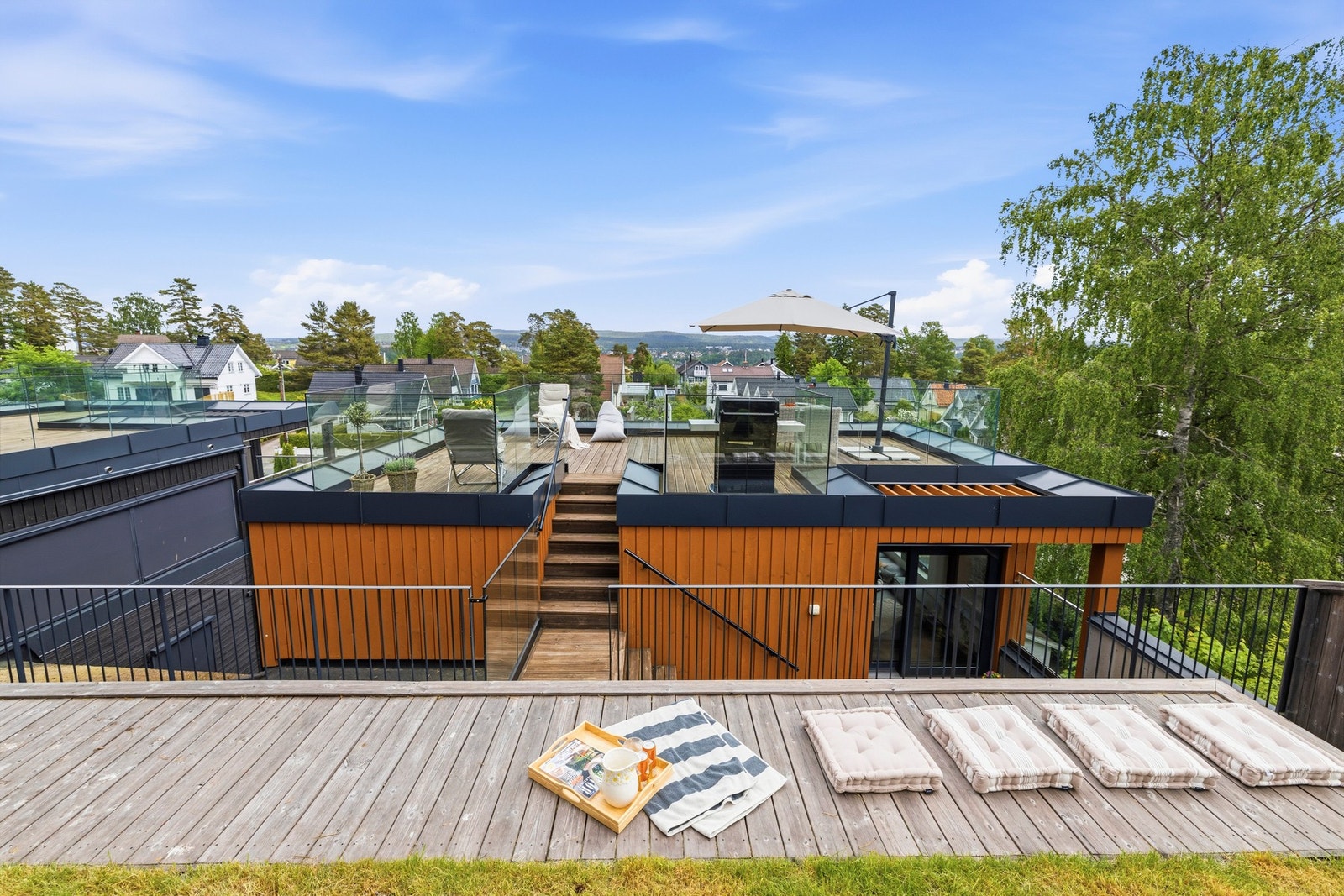 Videre leder trappen opp til en av boligens mange høydepunkter - takterrassen, med gressplen i bakkant. Galleribilde