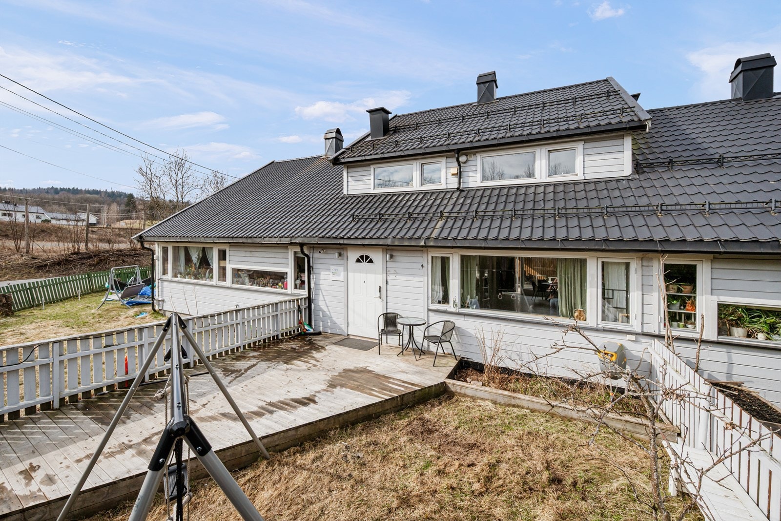 Rekkehuset har liggende bordkledning og tak tekket med stålplater. Galleribilde