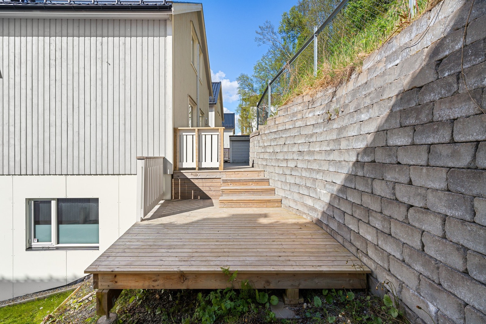 Tomten er opparbeidet med terrasser og forstøtningsmurer i betongstein. Galleribilde