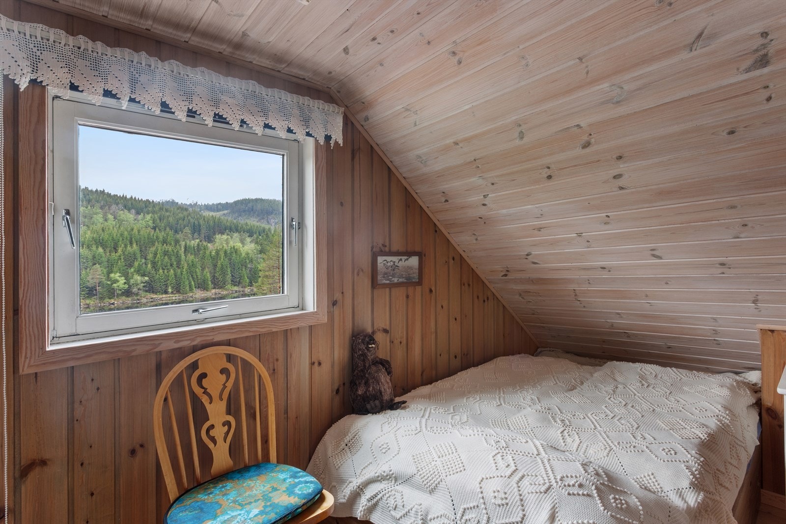 Utsikt mot skogen fra soveromsvinduet på loftet. Galleribilde