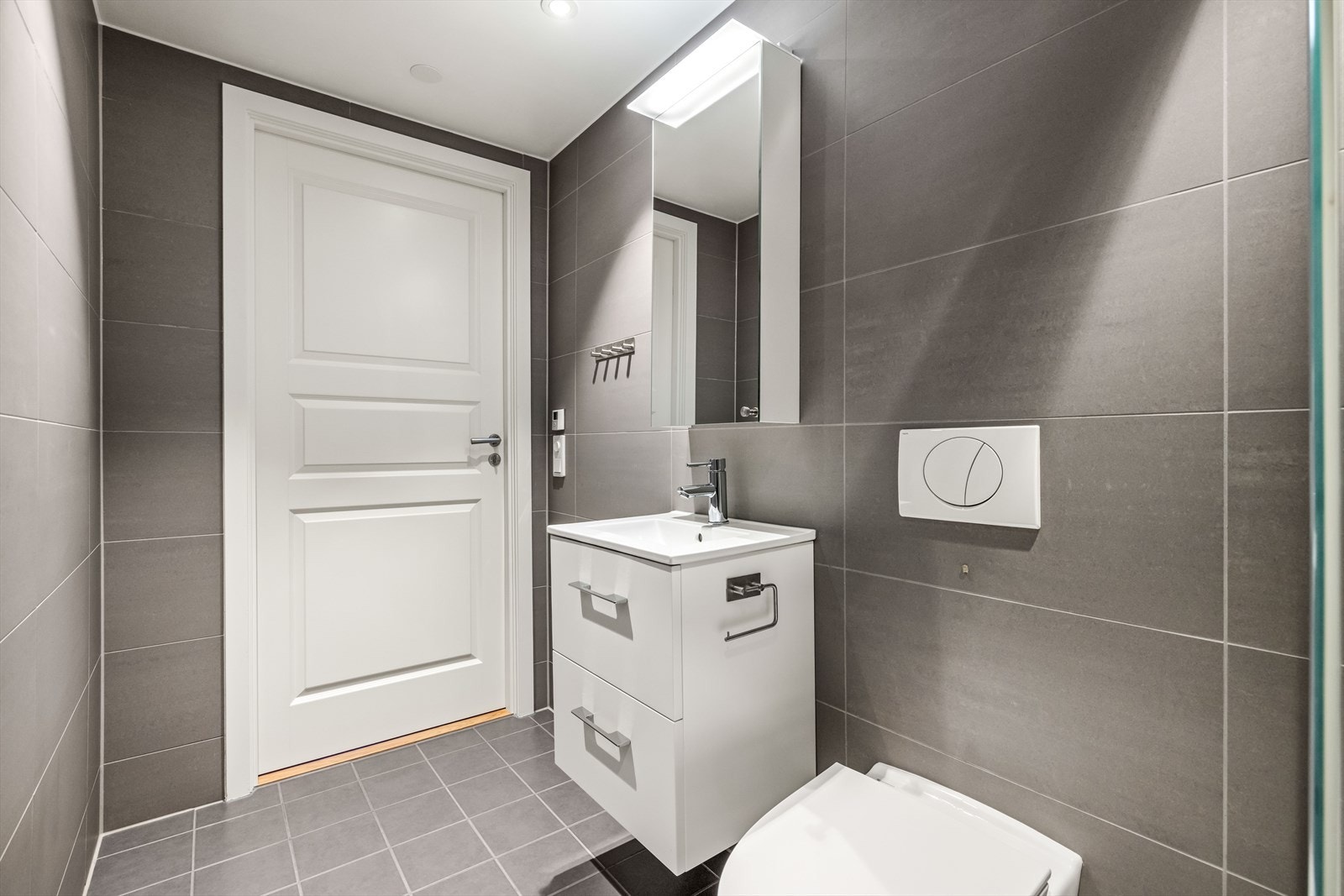 Badet har flislagte overflater, vannbåren gulvvarme, downlights og mekanisk atrekk. Galleribilde