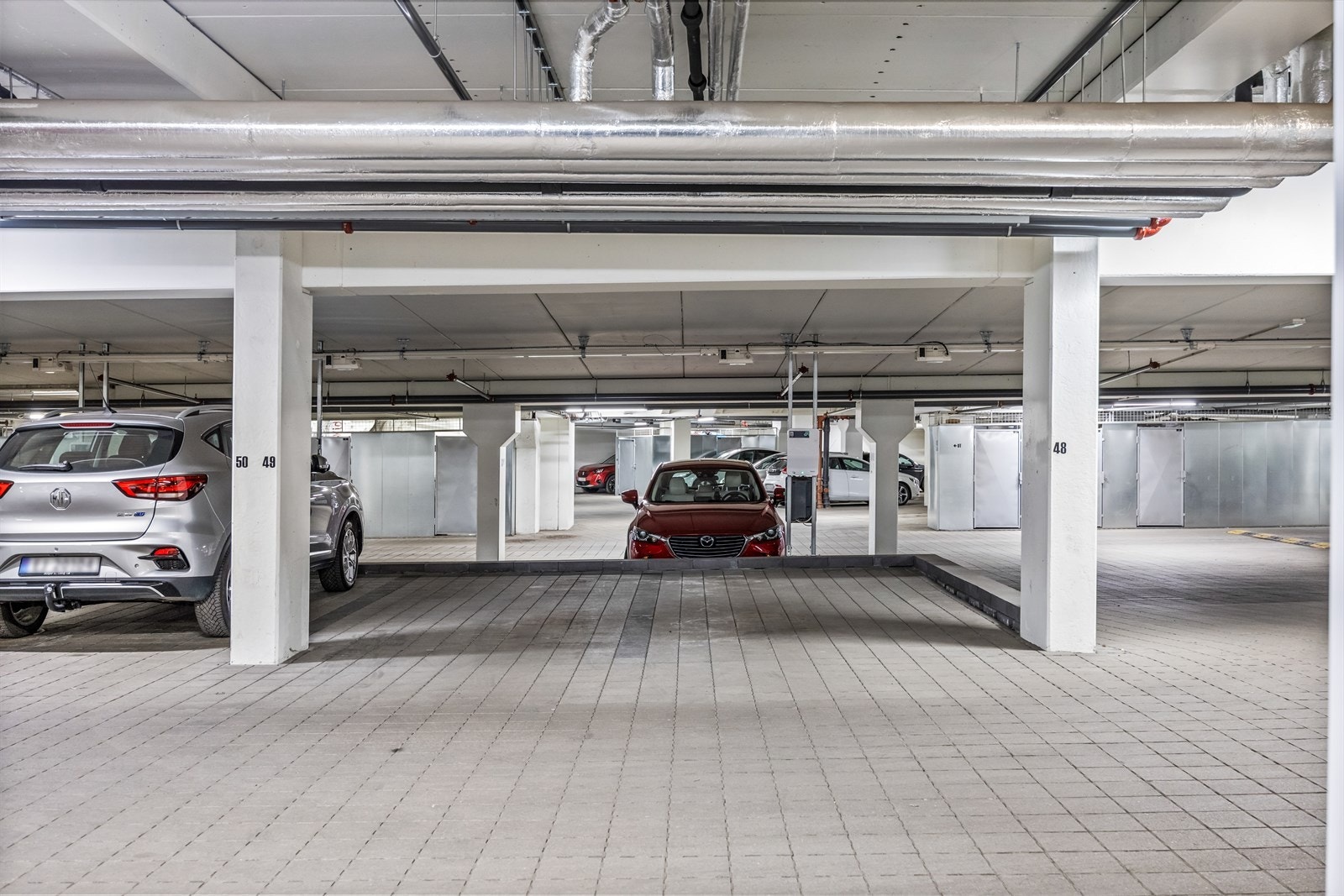 Det medfølger to garasjeplasser (48 og 49) ved siden av hverandre. Én elbillader er montert (plass nr. 48) og kan i følge eier benyttes på begge plassene. Galleribilde