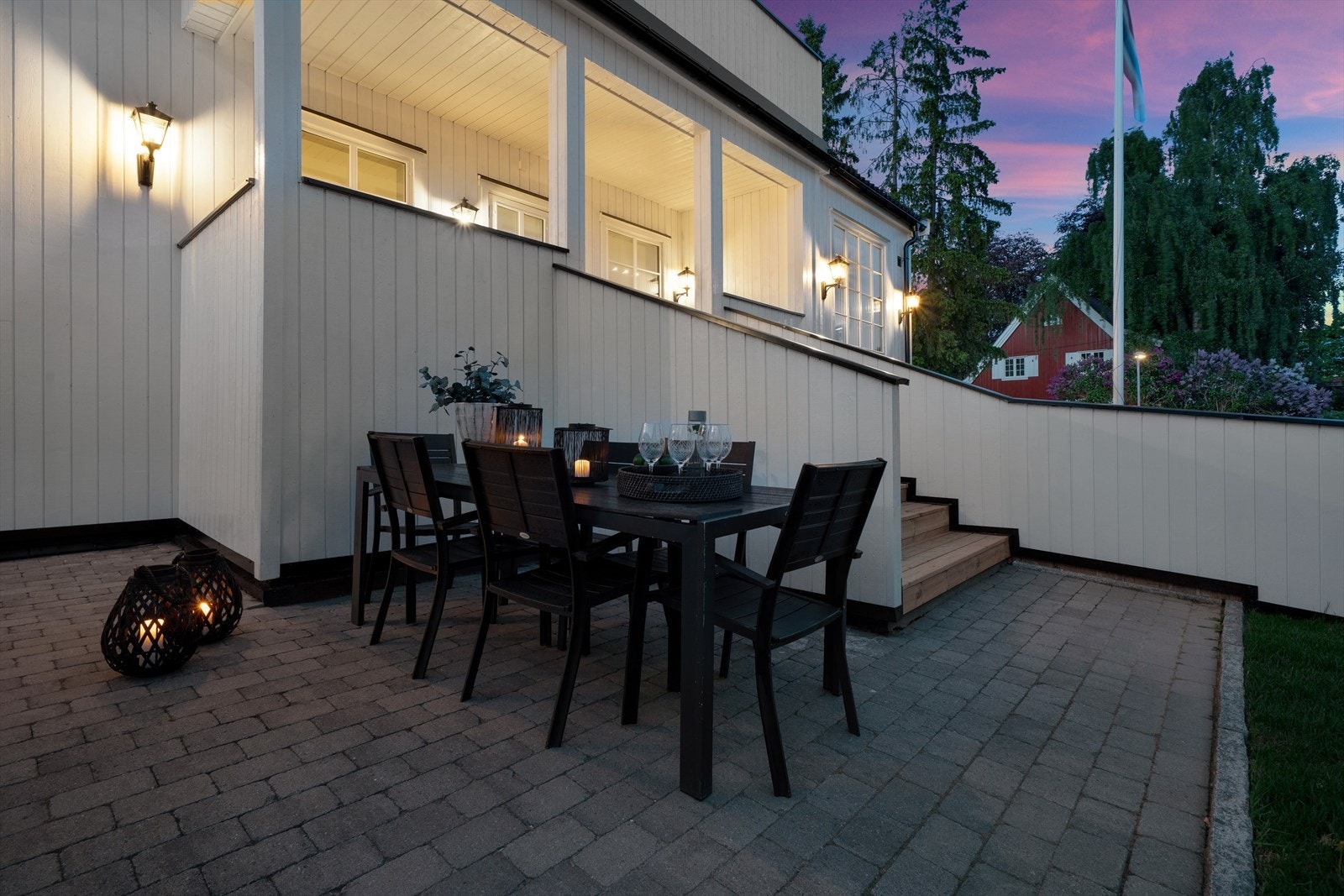 Terrasse med trapp ned til steinlagt uteplass Galleribilde