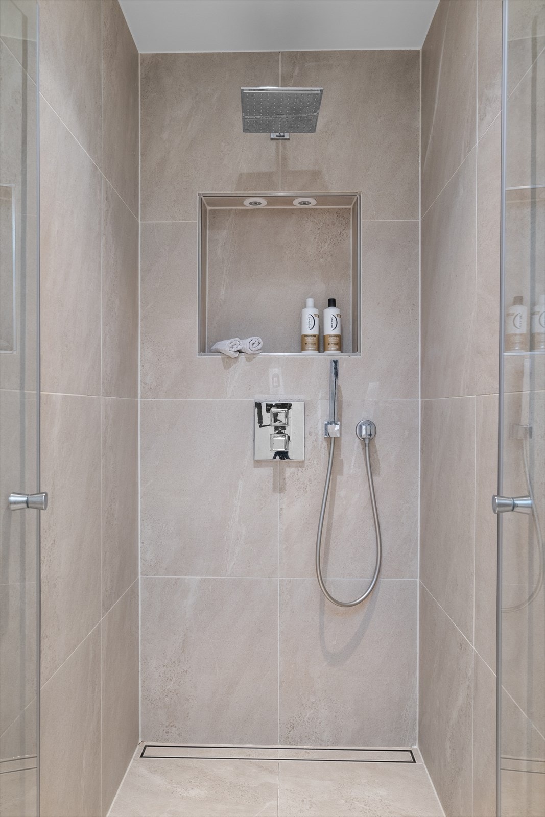 Dusjhjørne med glassdør og regnfallsdusj. Badet har mekanisk avtrekk. Galleribilde