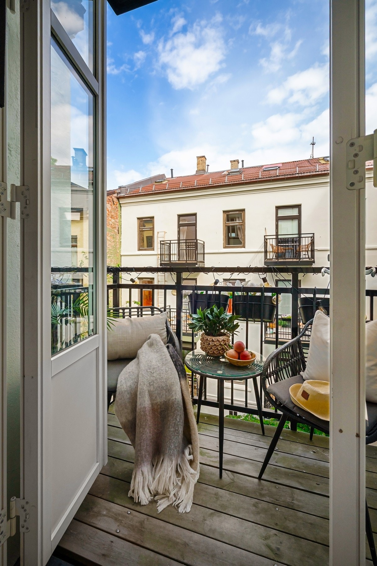 Balkongen har dekke av terrassebord, rekkverk i stål og vender ut mot en nydelig, rolig bakgård. Galleribilde