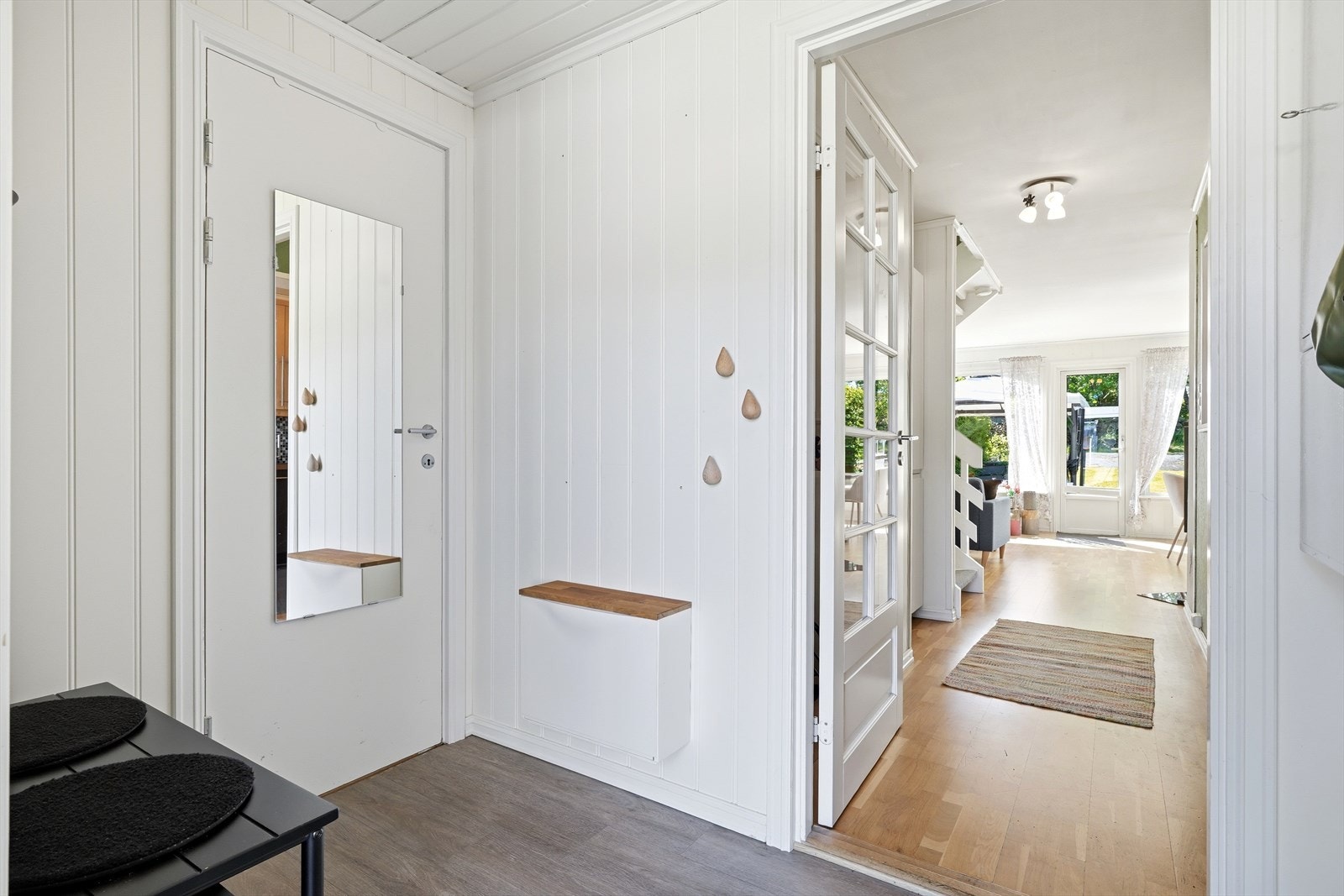 En dør med glassfelt skiller entréen fra stuen og bidrar til en åpen romfølelse. Galleribilde