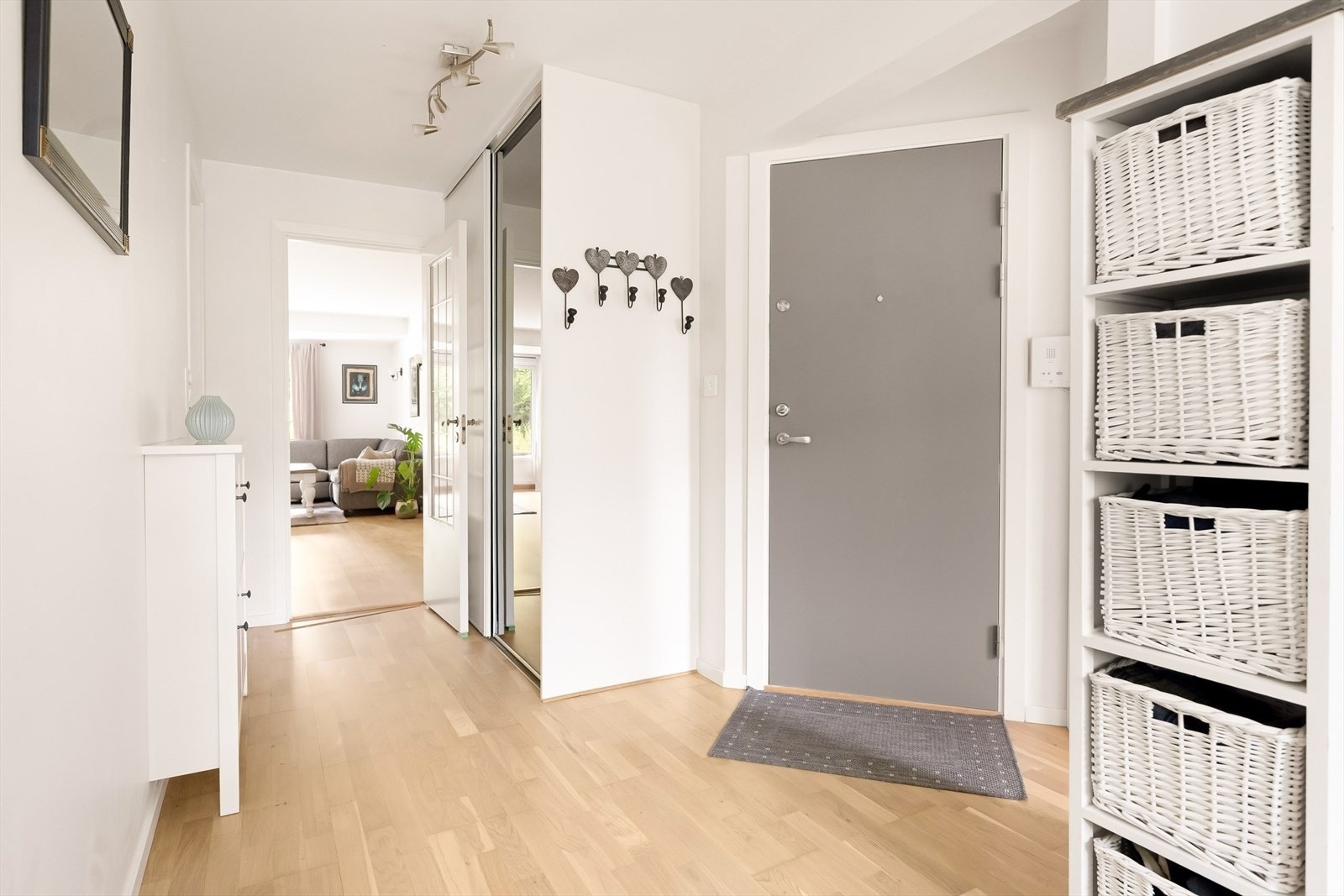 Velkommen inn! Entréen gir et lyst og imøtekommende førsteinntrykk, med lysmalte veggflater og en enhetlig parkett som videreføres inn i leilighetens øvrige oppholdsrom. Galleribilde