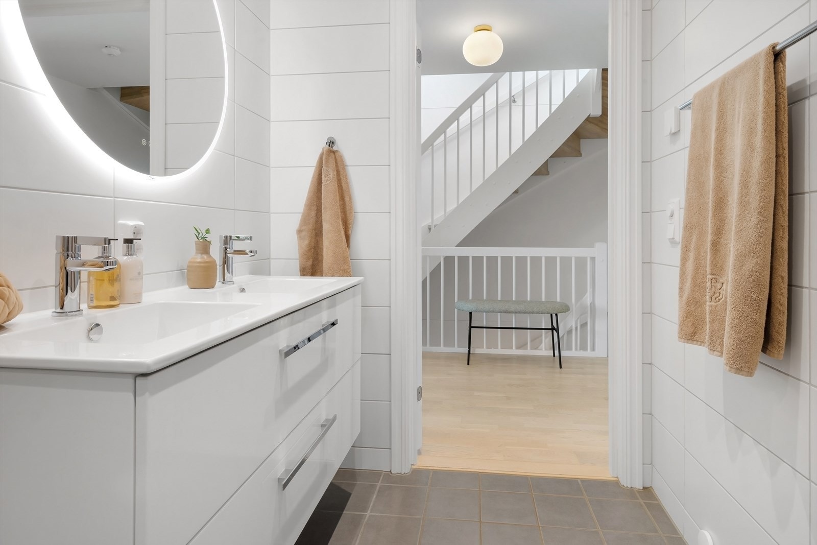 Pent baderom med flislagte overflater, vannbåren gulvvarme og downlights i taket. Galleribilde