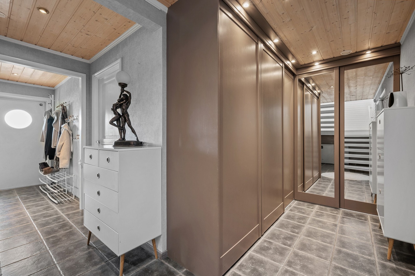 Romslig, flislagt entré/gang med gode oppbevaringsmuligheter i store skyvedørsgarderober. Galleribilde