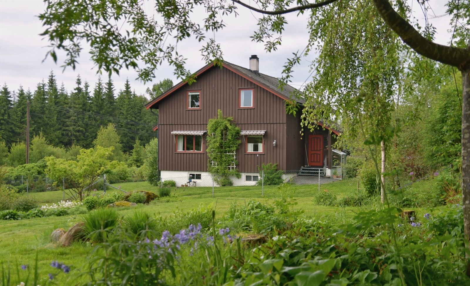 Eiendommen ligger på en flat og noe kupert tomt med gruset innkjøring og en romslig, inngjerdet hage. Galleribilde