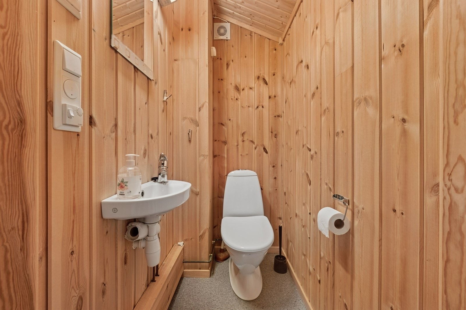 Toalettrommet har panel på veggene og belegg på gulvet. Galleribilde