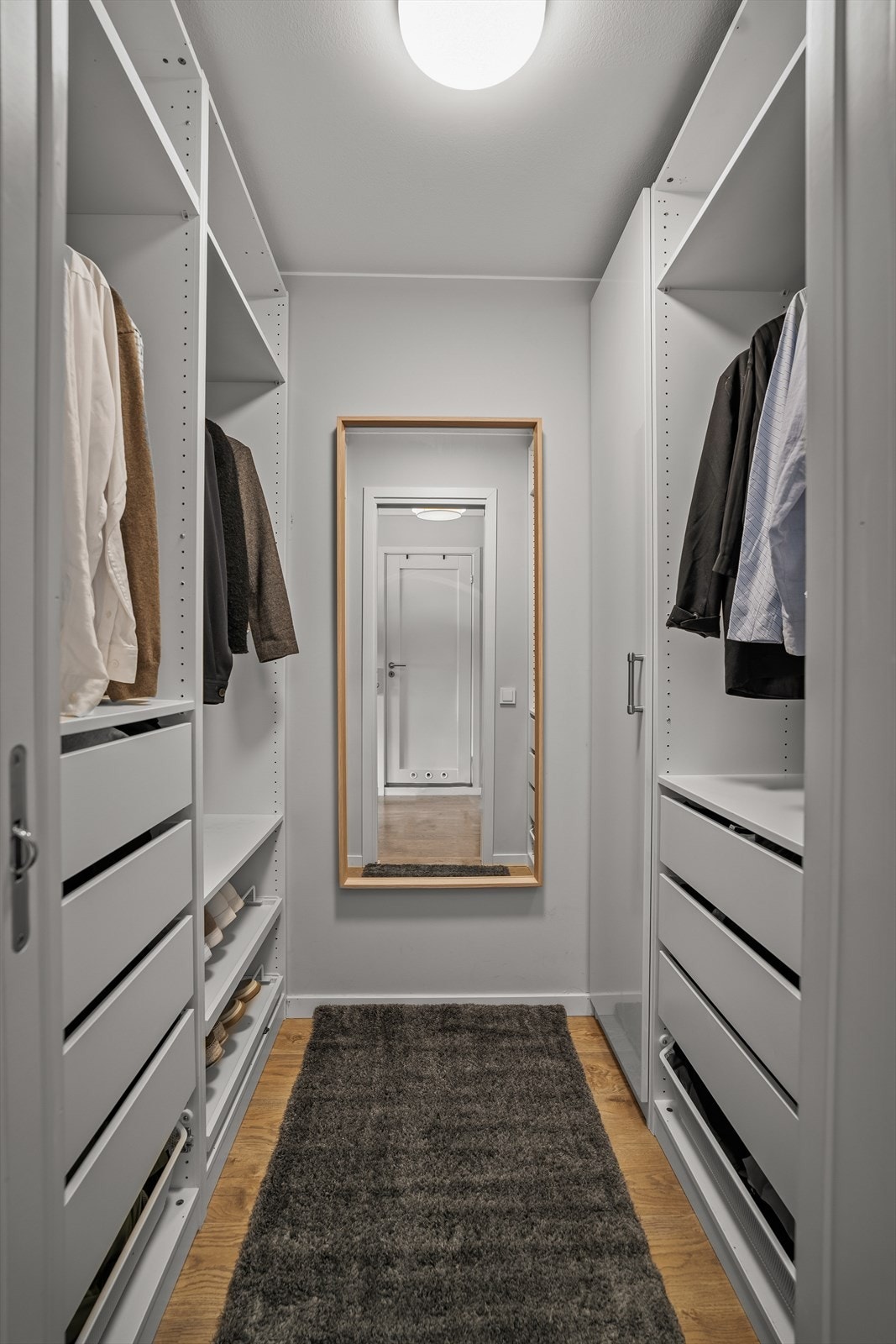 Fra gangen har du adkomst til en stor, separat garderobe med walk-in-løsning. Garderoberommet gir svært gode oppbevaringsmuligheter og bidrar til en ryddig og praktisk hverdag med god plass til klær, sko og annet utstyr. Galleribilde
