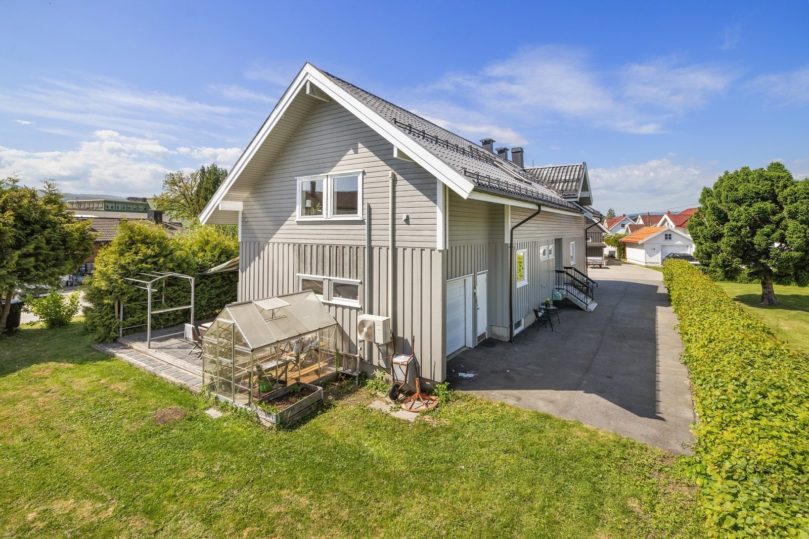 Eiendommen har en stor hage med drivhus og flere uteplasser. Galleribilde