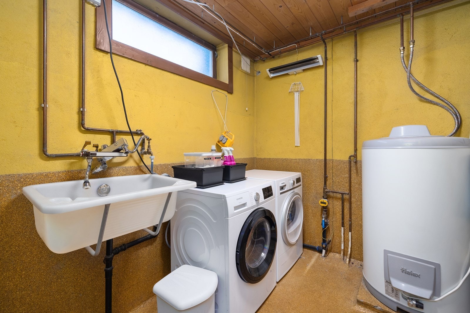 Praktisk vaskerom i kjelleren med epoxy på gulv, opplegg for vaskemaskin og skyllekar. Galleribilde