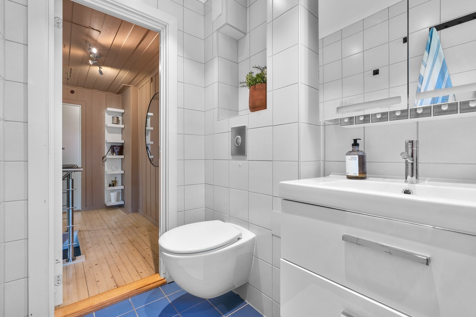 Badet er utstyrt med vegghengt toalett, servantskap og badekar med dusjløsning. Galleribilde