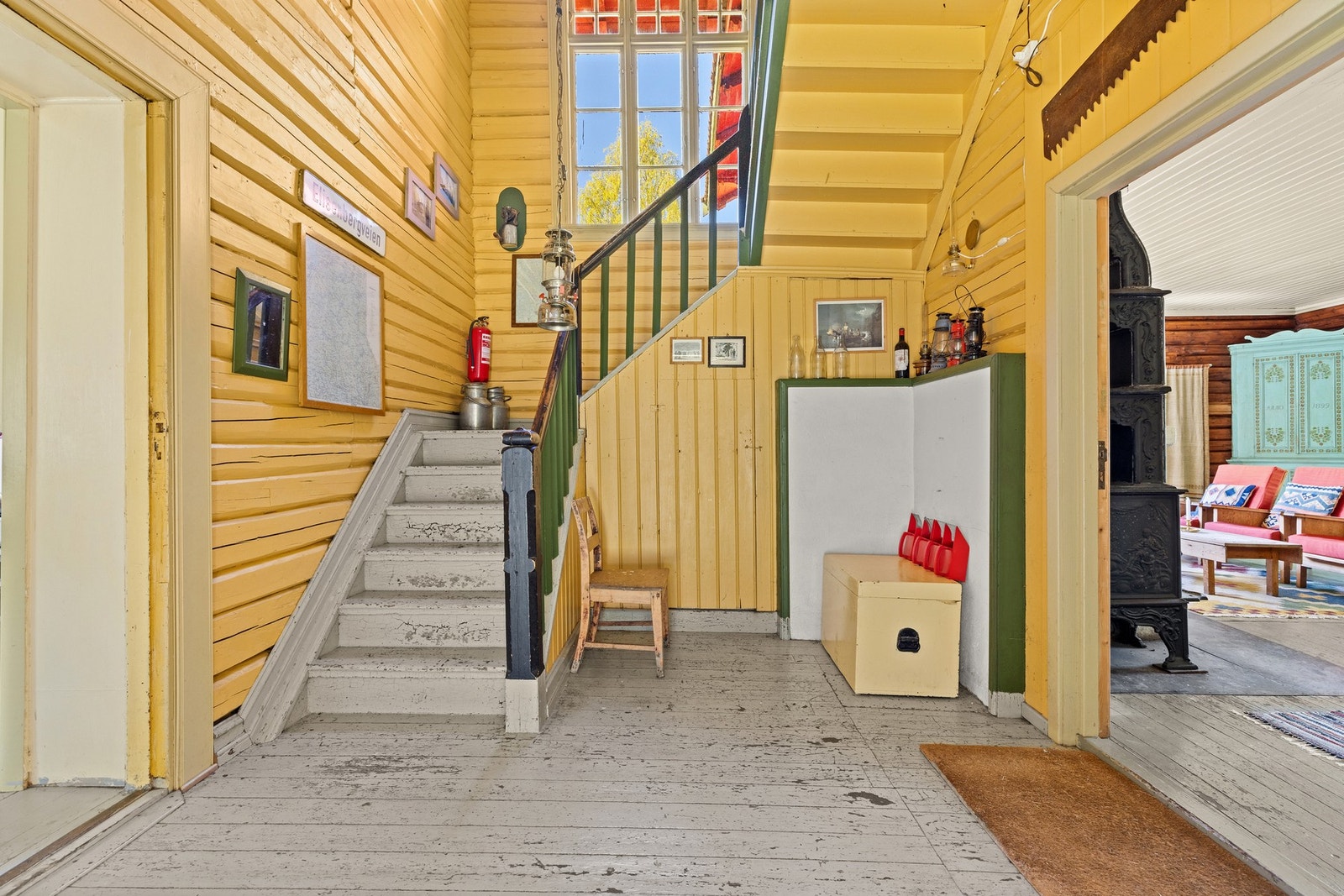 Hallen har god takhøyde og fremstår som et naturlig samlingspunkt i boligen, med flott trapp opp til 2. etasje og originale detaljer som understreker hyttas karakter og sjel. Galleribilde