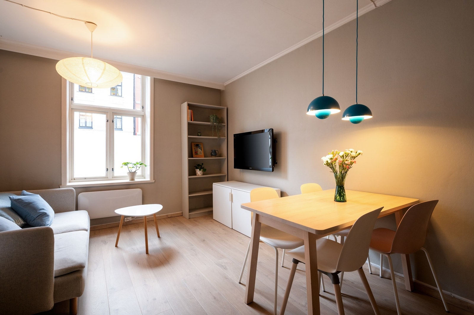 Innvendig har du åpen planløsning med moderne kjøkken og god plass til både spisebord og sofa Galleribilde