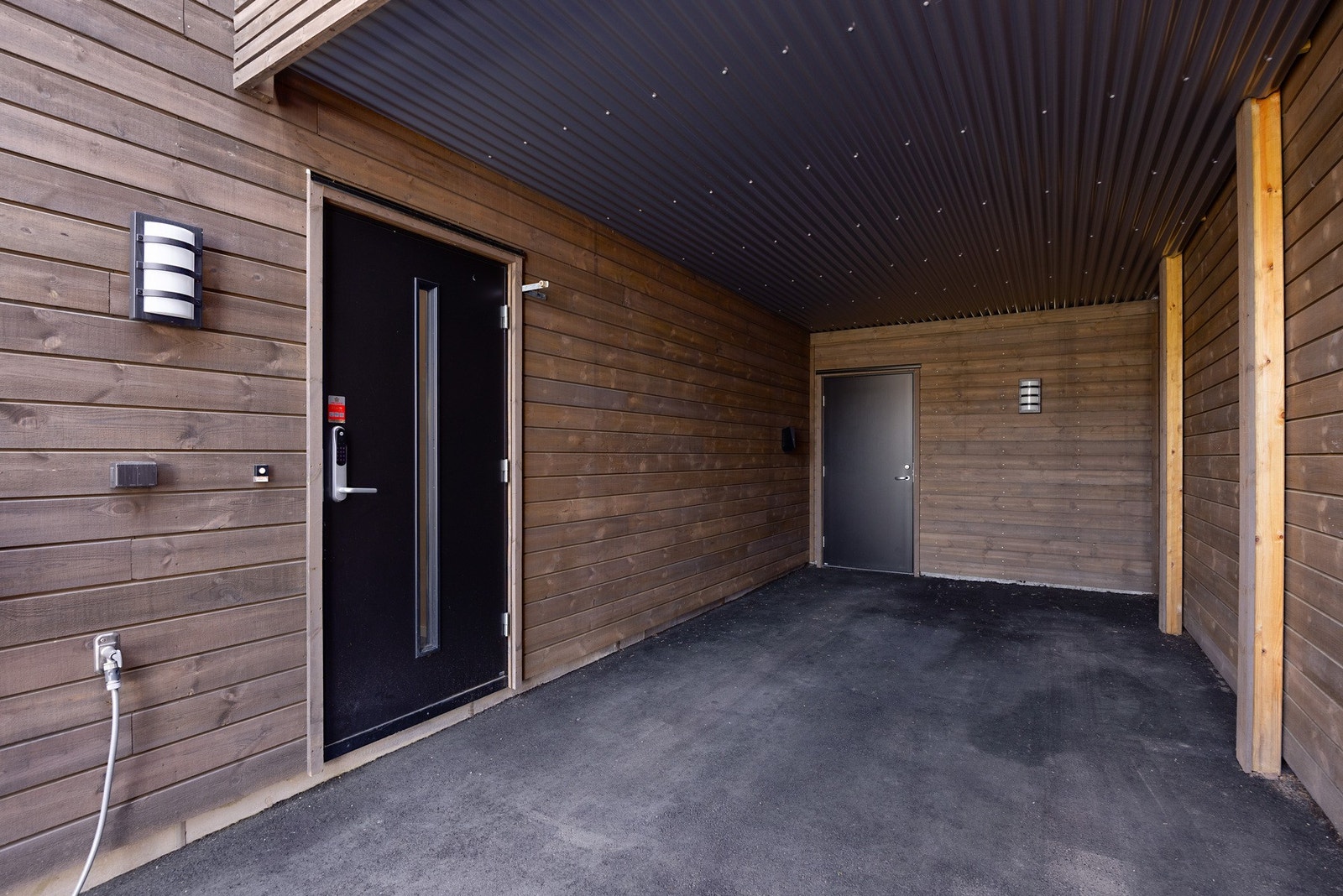 Asfaltert carport med lader. I enden er det bod med god lagringsplass. Galleribilde