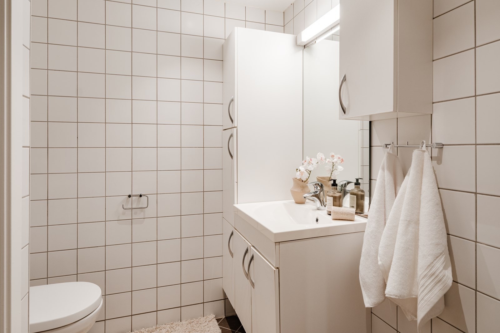 Innredningen består av servant med underskap, speil og vegghengt toalett. Badet har mekanisk avtrekk. Galleribilde