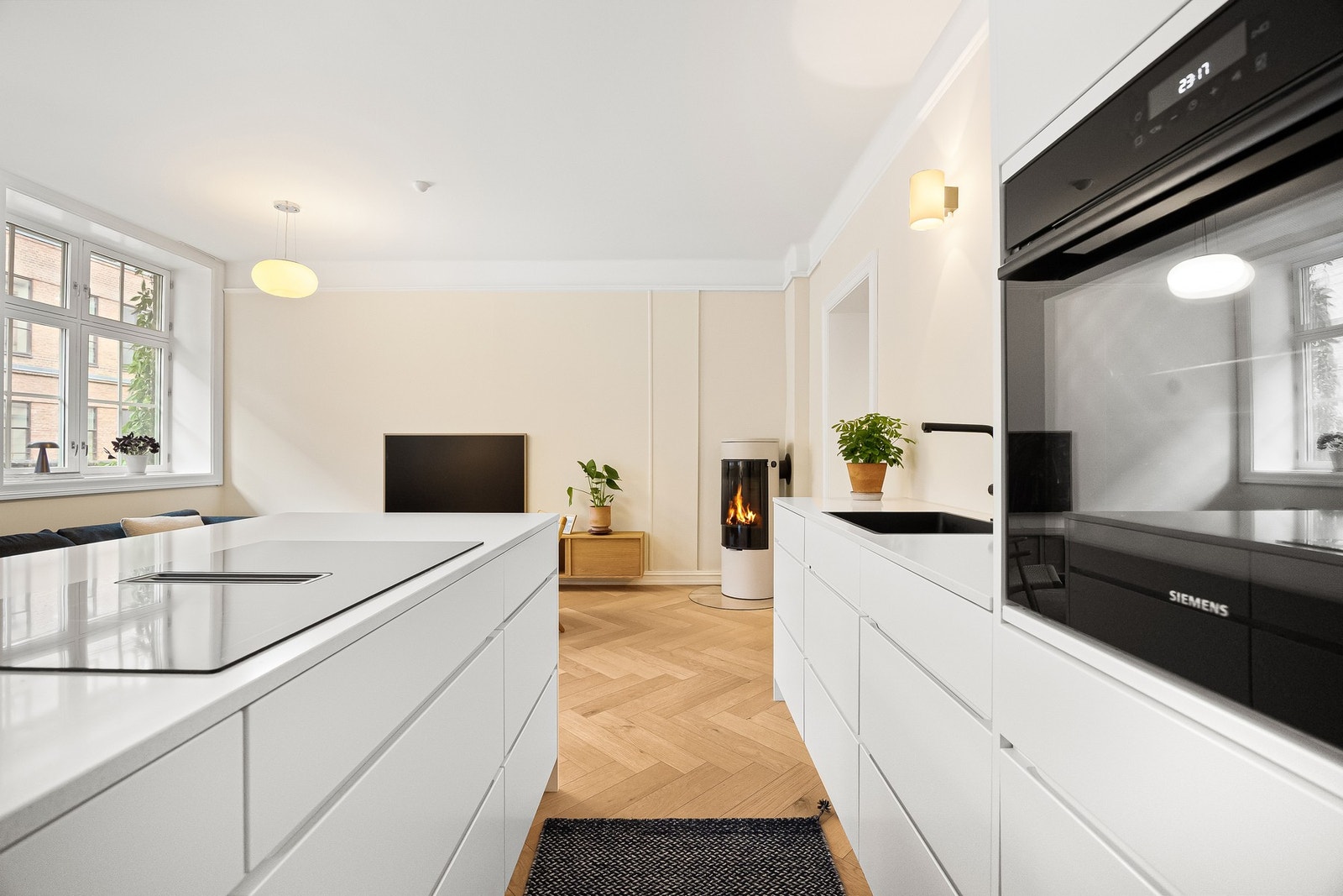 Moderne og gjennomført utforming med glatte, folierte fronter og slitesterk benkeplate i kompositt. Galleribilde