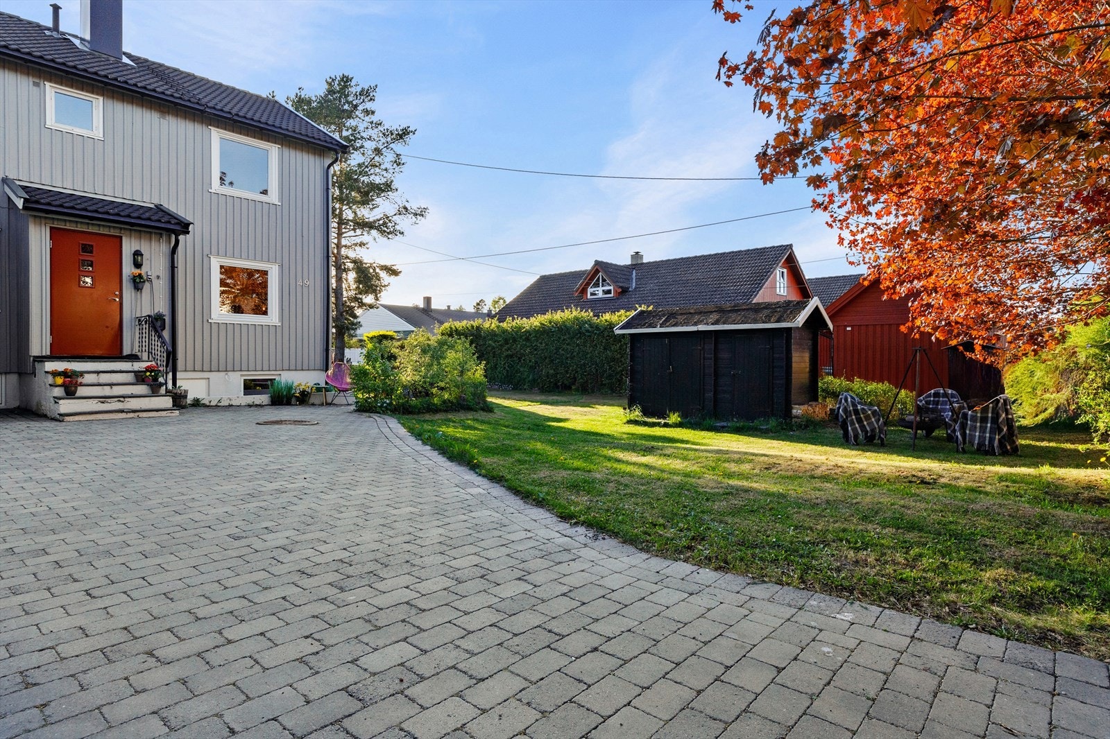 Gårdsplass med belegningsstein og biloppstillingsplass. Galleribilde