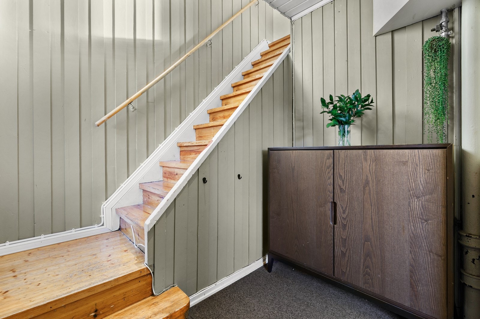 Lakkert tretrapp med originale detaljer leder opp til andre etasje. Galleribilde