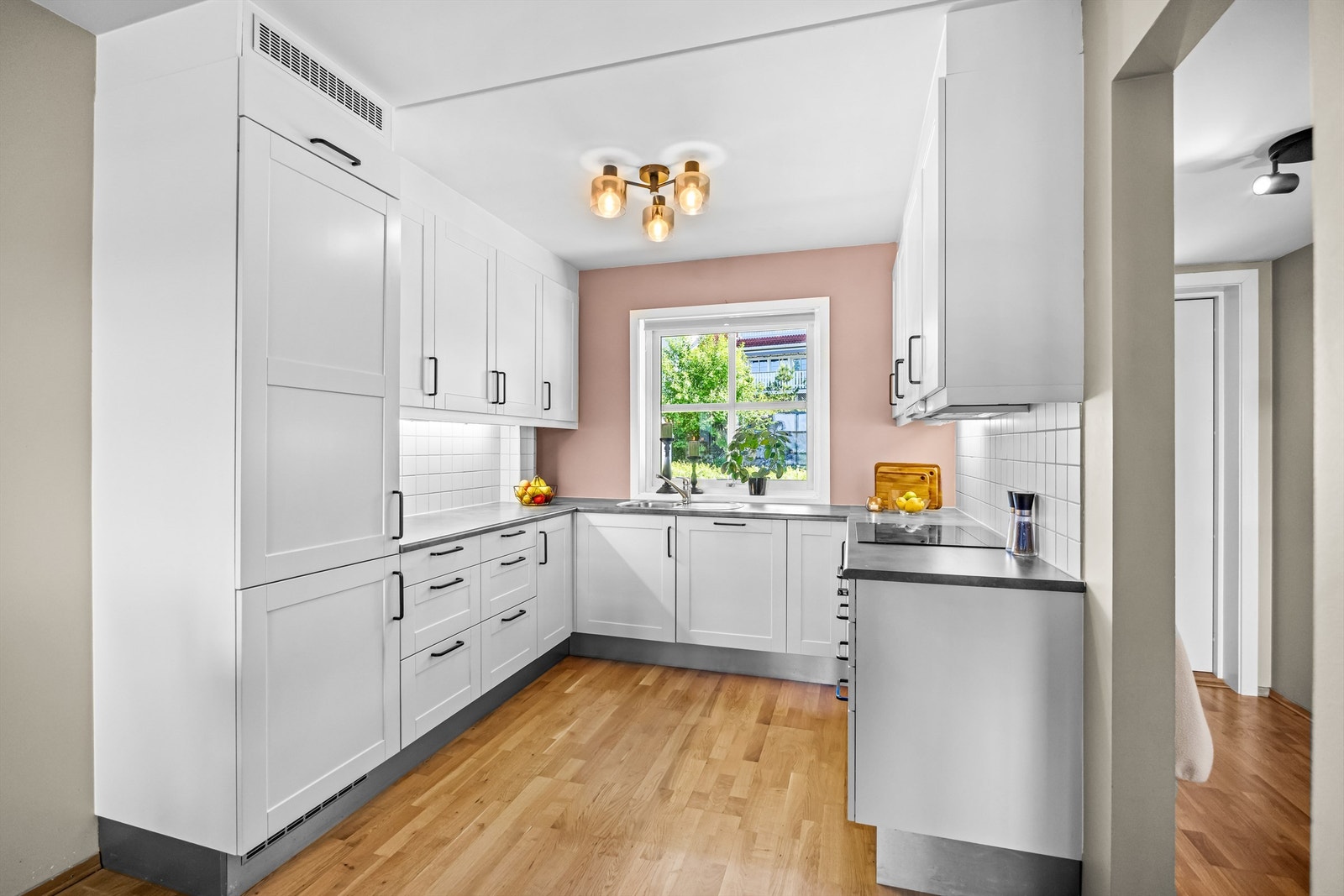 Kjøkkeninnredning med profilerte fronter og laminert benkeplate. Galleribilde
