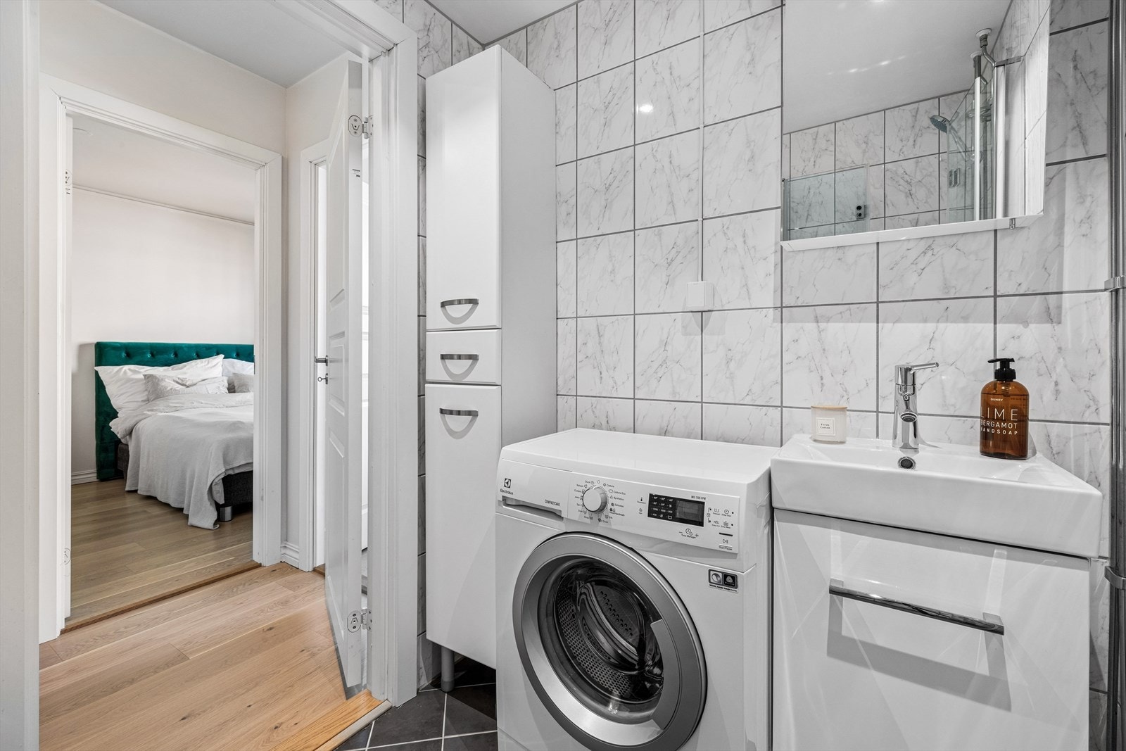 Badet har opplegg for vaskemaskin. Servant med servantskap, speilskap, og dusjdører fra 2019. Galleribilde