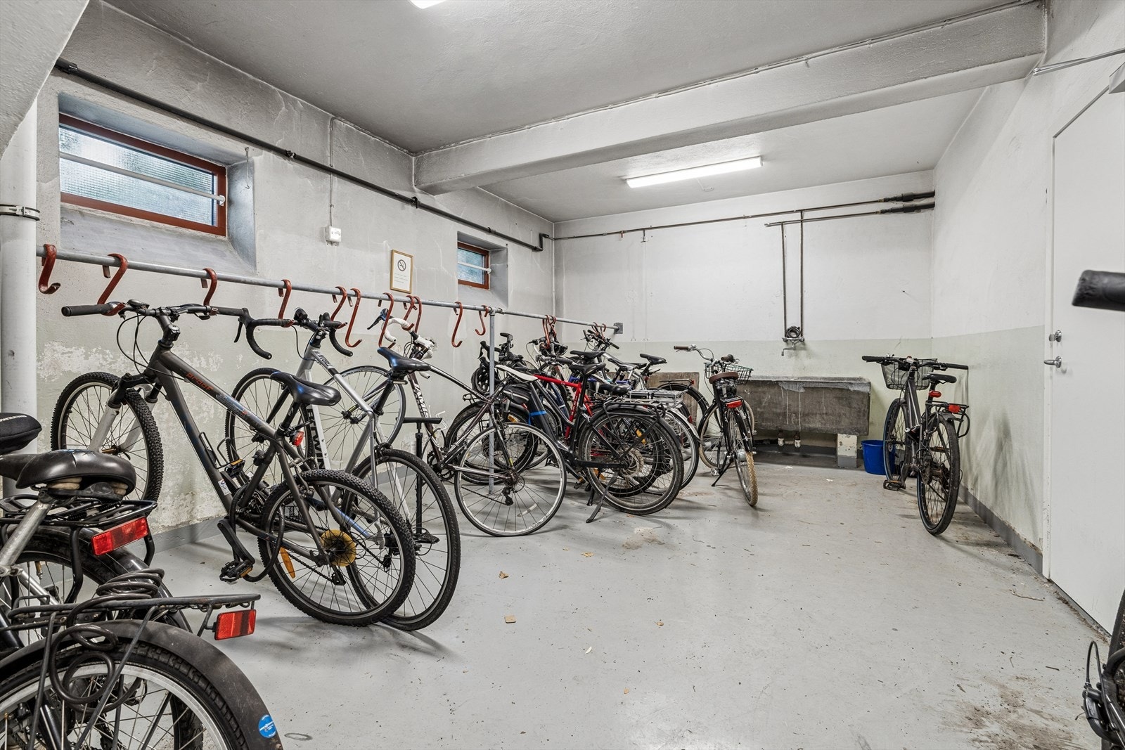 Leiligheten disponerer to boder på til sammen 13 m². Det medfølger ekstra fryser i kjellerboden. Her vises felles sykkelparkering i kjelleren. Galleribilde