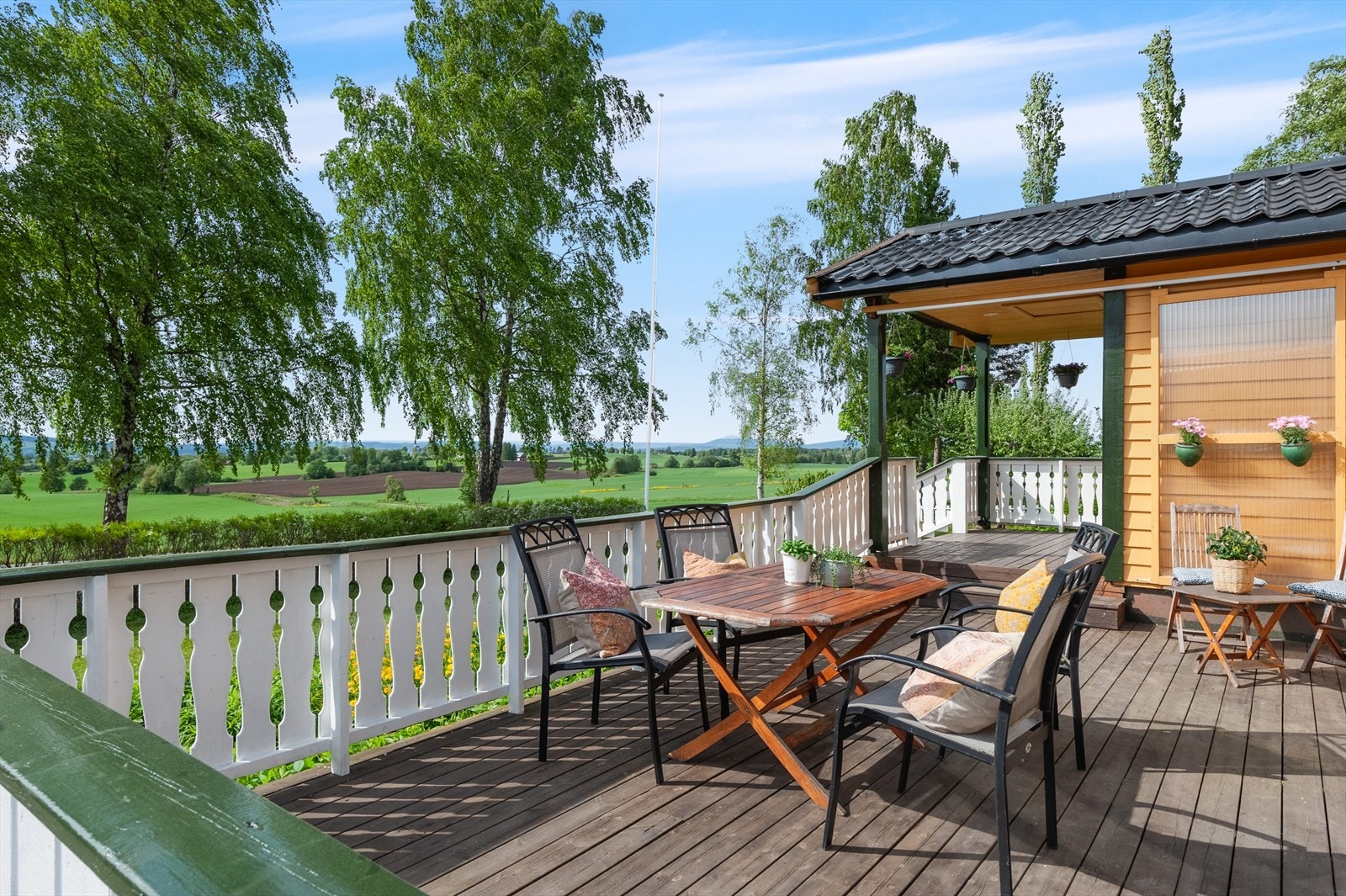 Terrassen er bygget med spaltegulv i tre og har et solid rekkverk. Galleribilde
