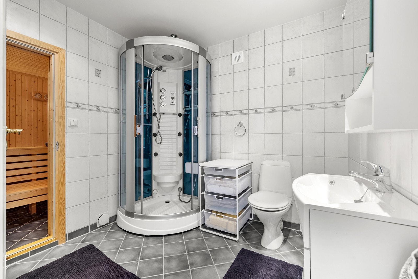 Badet i underetasjen har flislagt gulv, dusjkabinett og toalett. Herfra er det inngang til badstuen. Galleribilde