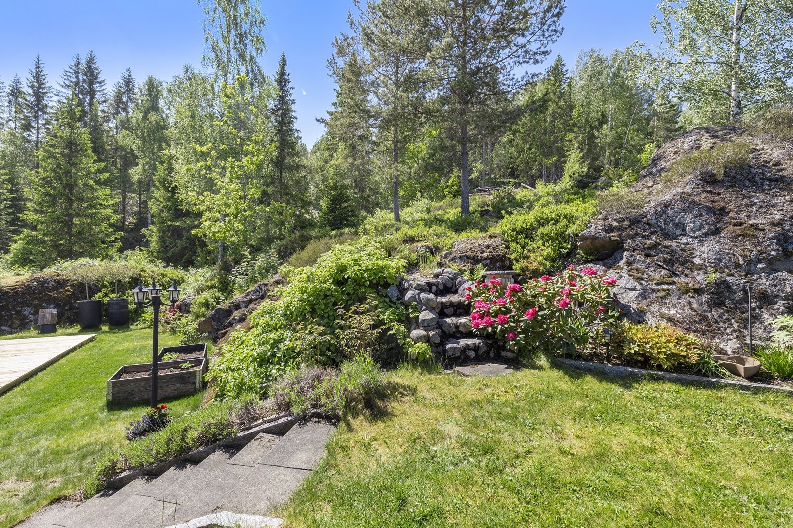 Den velstelte hagen er opparbeidet med plen, beplantning og en flott natursteinstrapp som følger terrengets naturlige utforming. Galleribilde