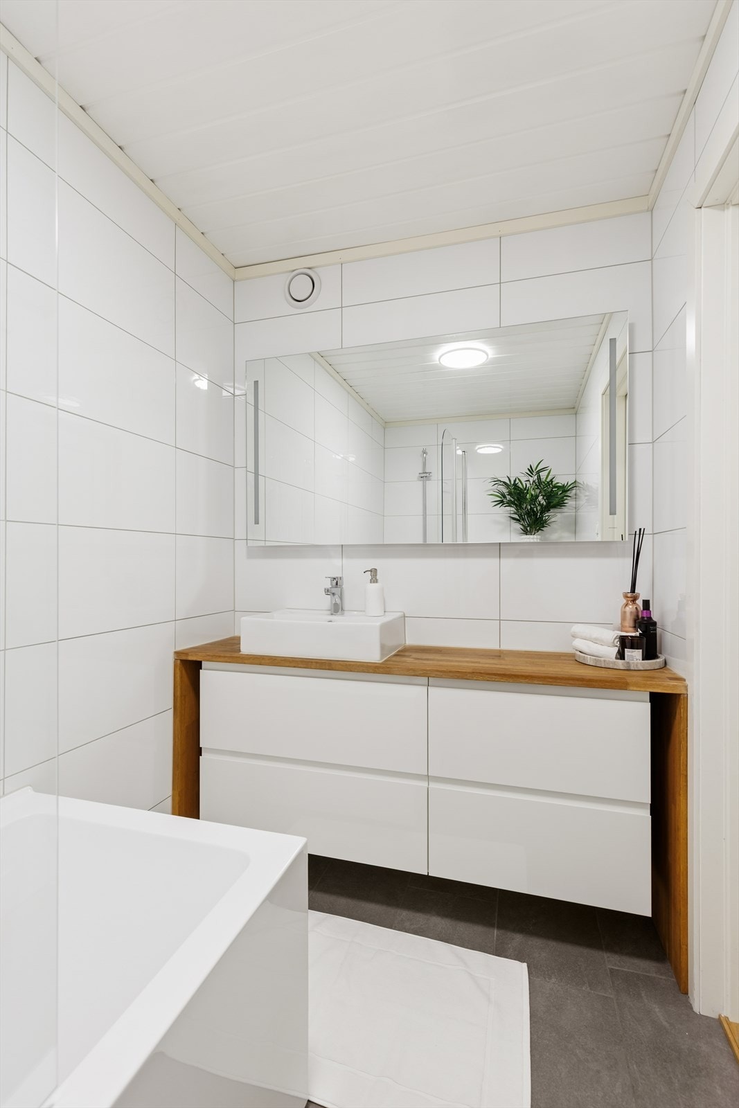 Lekkert, lyst bad med servant, veggehengt toalett og dusj/badekar. Galleribilde