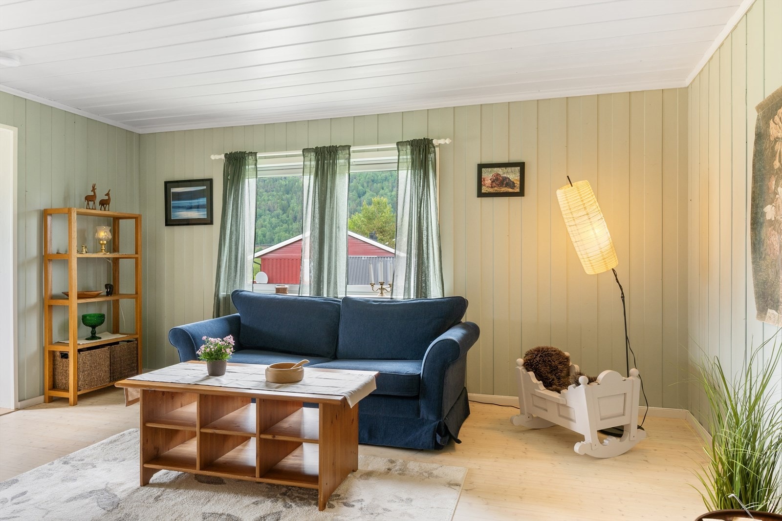 Gulvene i stua har furugulv og veggene har overflater av panel. Galleribilde