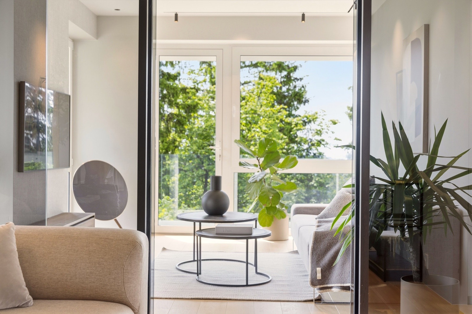 TV-stuen kan åpnes helt opp mot fellesarealene eller lukkes med skyvedører i sotet glass. Slik kan rommet enkelt tilpasses både sosiale sammenkomster og rolige stunder i mer private omgivelser. Galleribilde