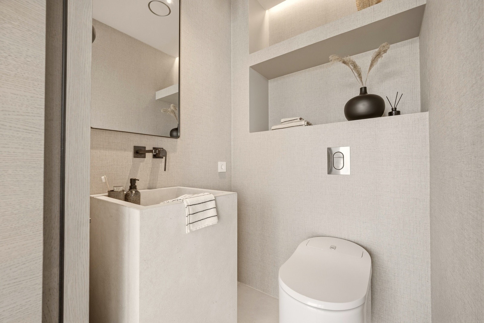 WC i tilknytning til kjøkken og stue i 2. etasje. Rommet er innredet med spesialbestilt steinservant fra Italia, japansk spyletoalett og innbygde nisjer med indirekte LED-belysning som skaper en rolig og sofistikert atmosfære. Lyssensor sørger for automat Galleribilde