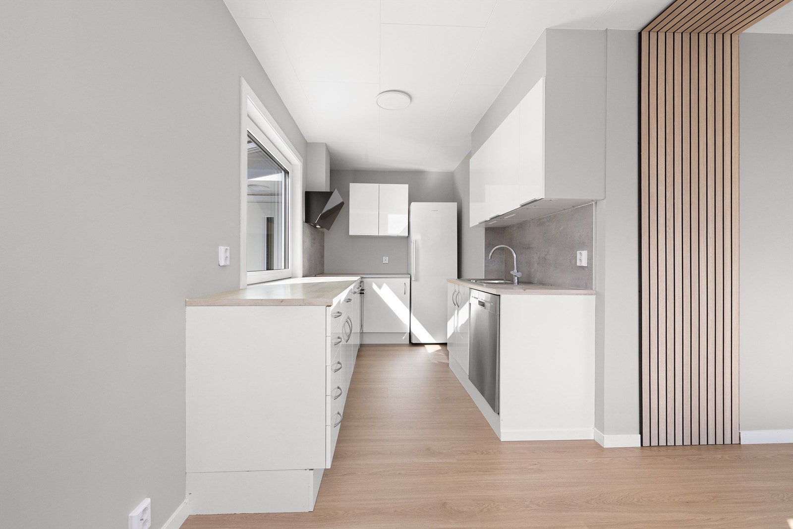 Kjøkkeninnredning fra IKEA med glatte fronter og laminat benkeplate. Galleribilde