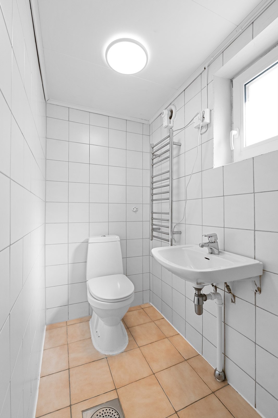 Badet er utstyrt med gulvstående toalett og dusj. Galleribilde