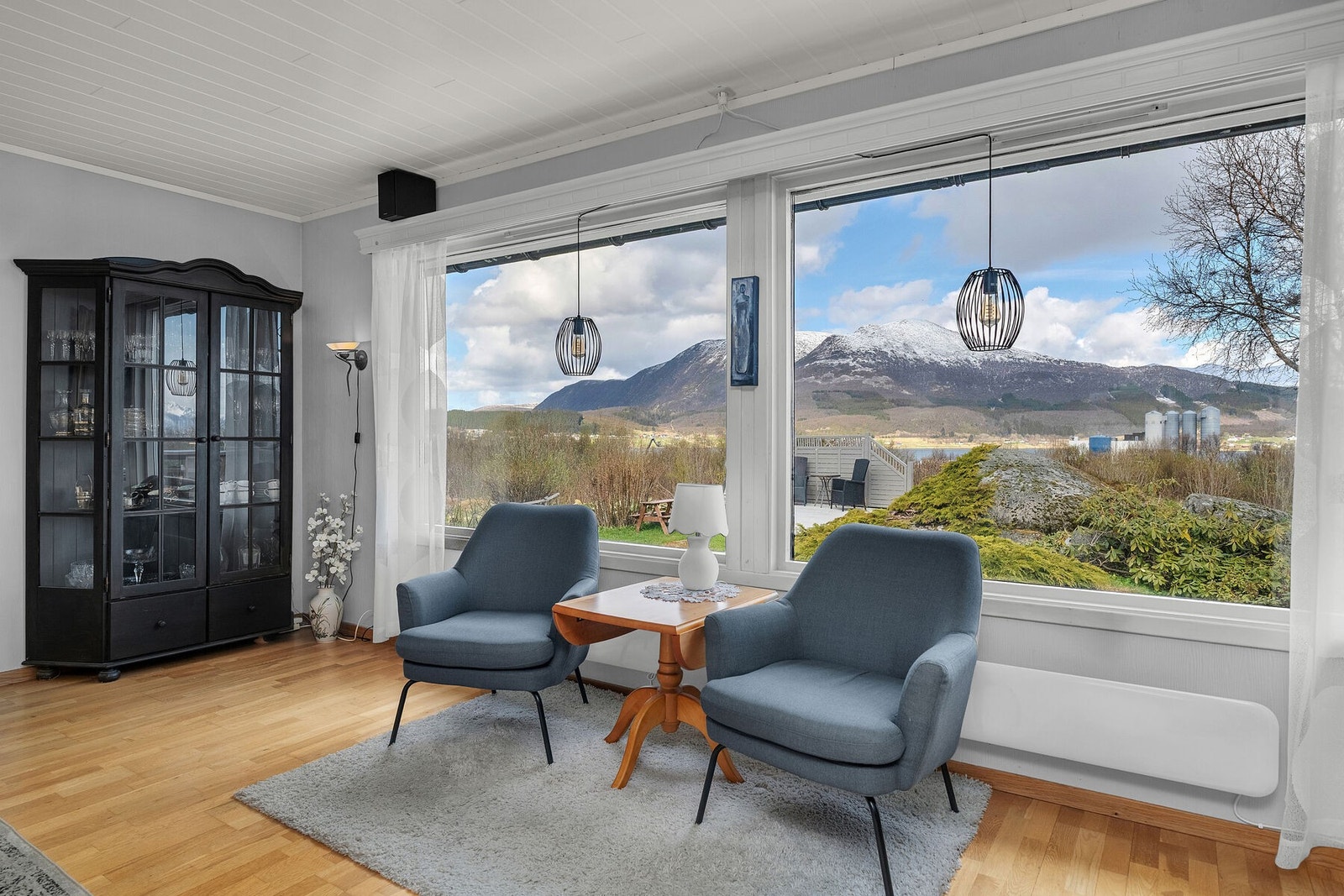Store vindusflater gir rikelig med dagslys og rammer inn utsikten mot fjellandskapet. Galleribilde