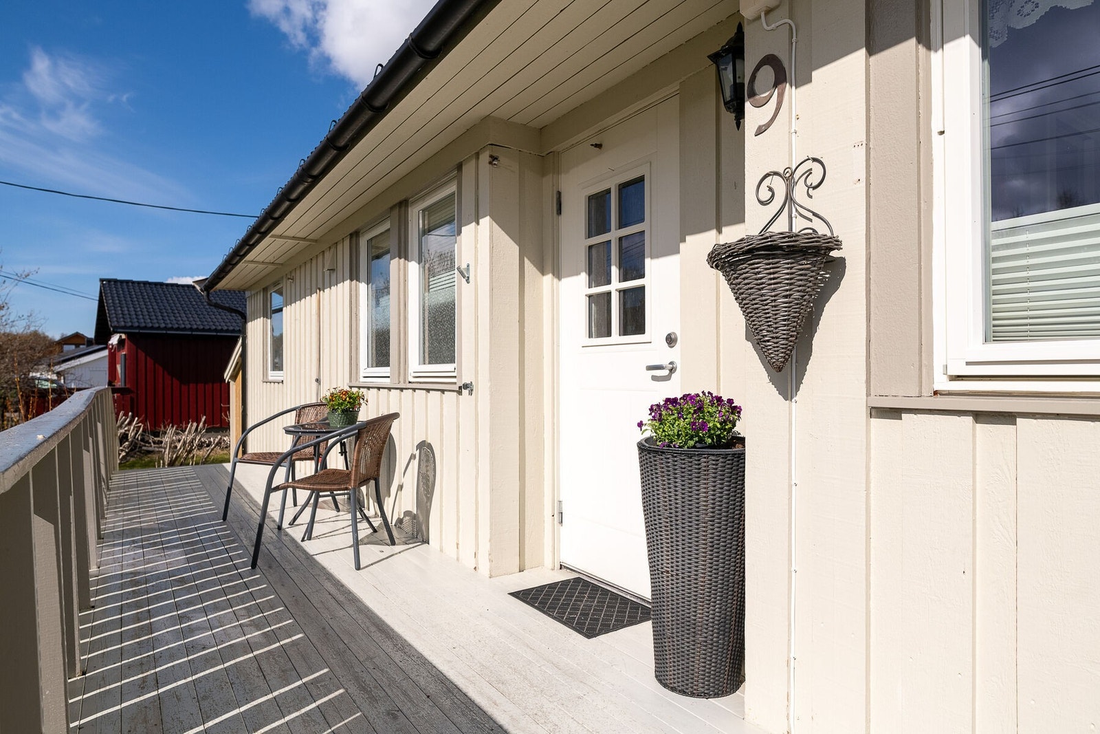 Overbygget inngangsparti med plass til en liten sittegruppe ved inngangsdøren. Galleribilde