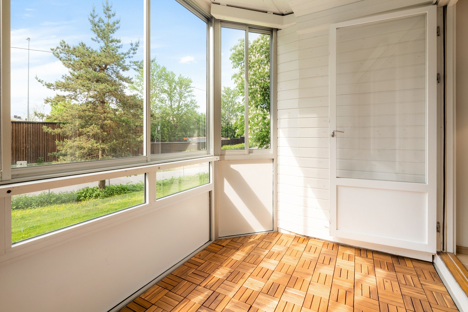Balkongen har treheller på gulv, rekkverk med skyvevinduer og downlights i himlingen. Galleribilde
