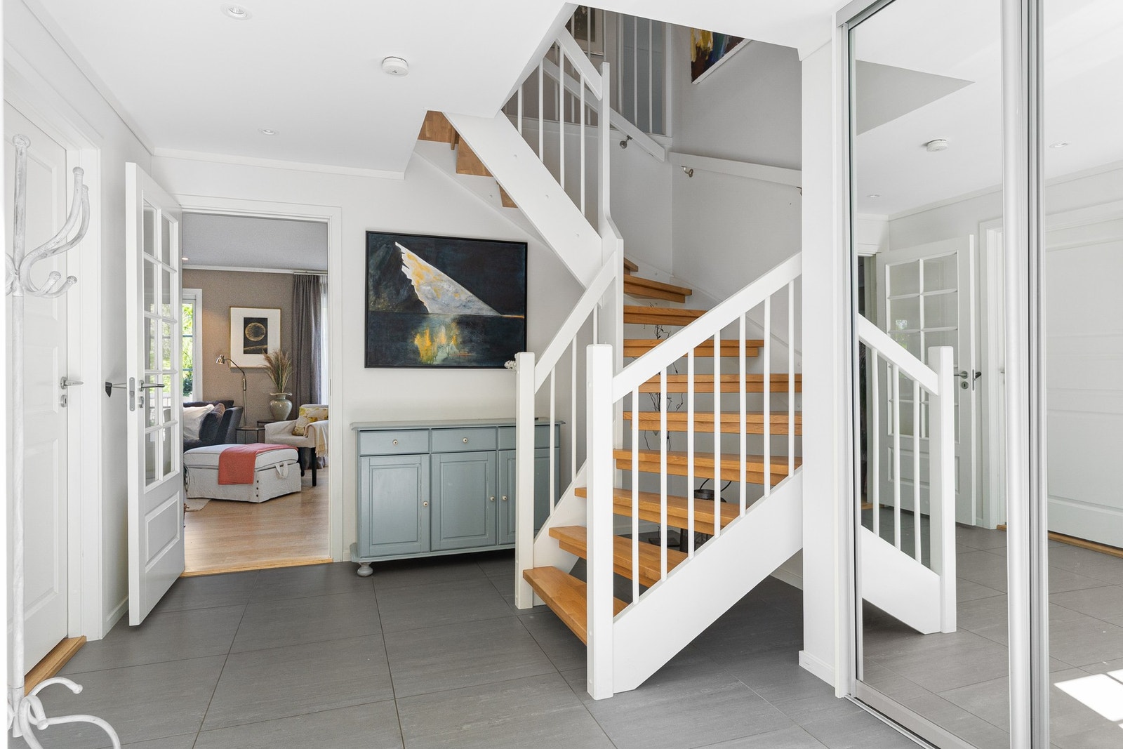 Fra hallen leder den elegante trappen videre opp i boligen. Her oppleves det luftig og åpent, med god takhøyde og et innbydende førsteinntrykk av boligen. Galleribilde