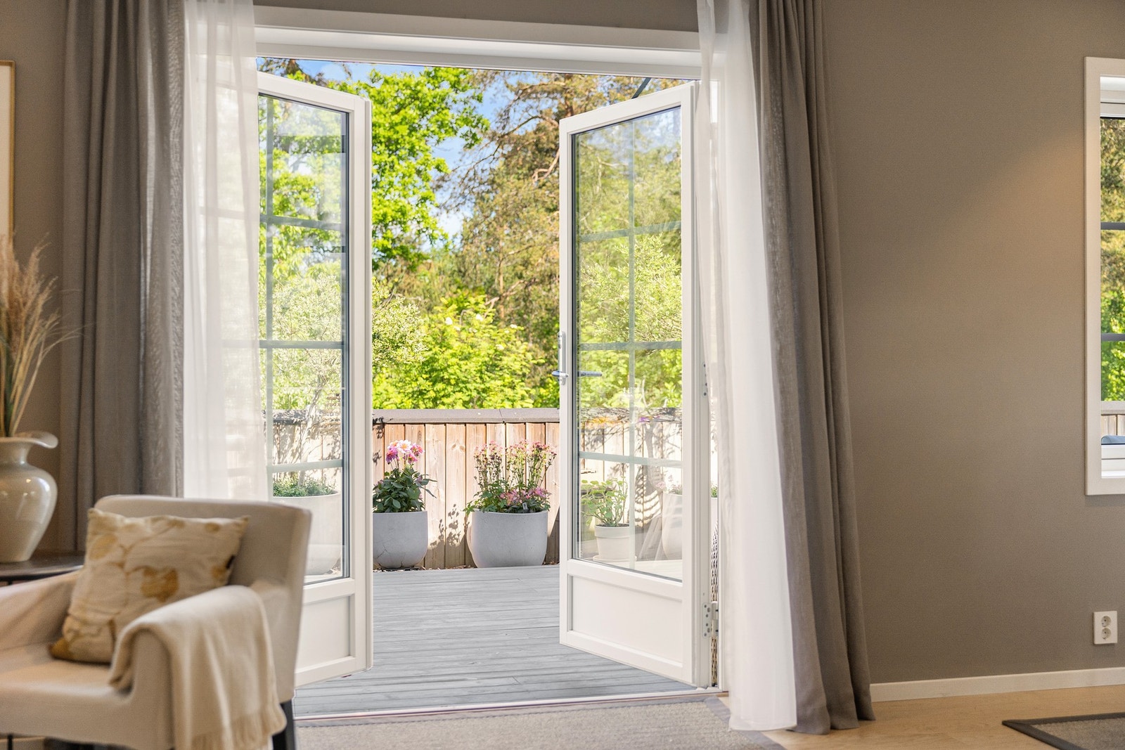 De doble terrassedørene visker ut skillet mellom inne og ute, og slipper inn rikelig med dagslys i oppholdsrommet. Galleribilde