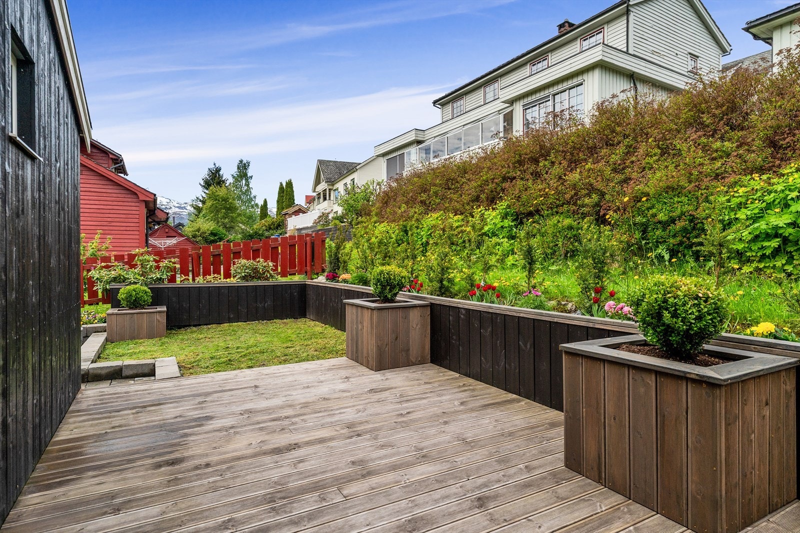 Terrassen er pent opparbeidet med blomsterbed og blomsterkasser. Galleribilde
