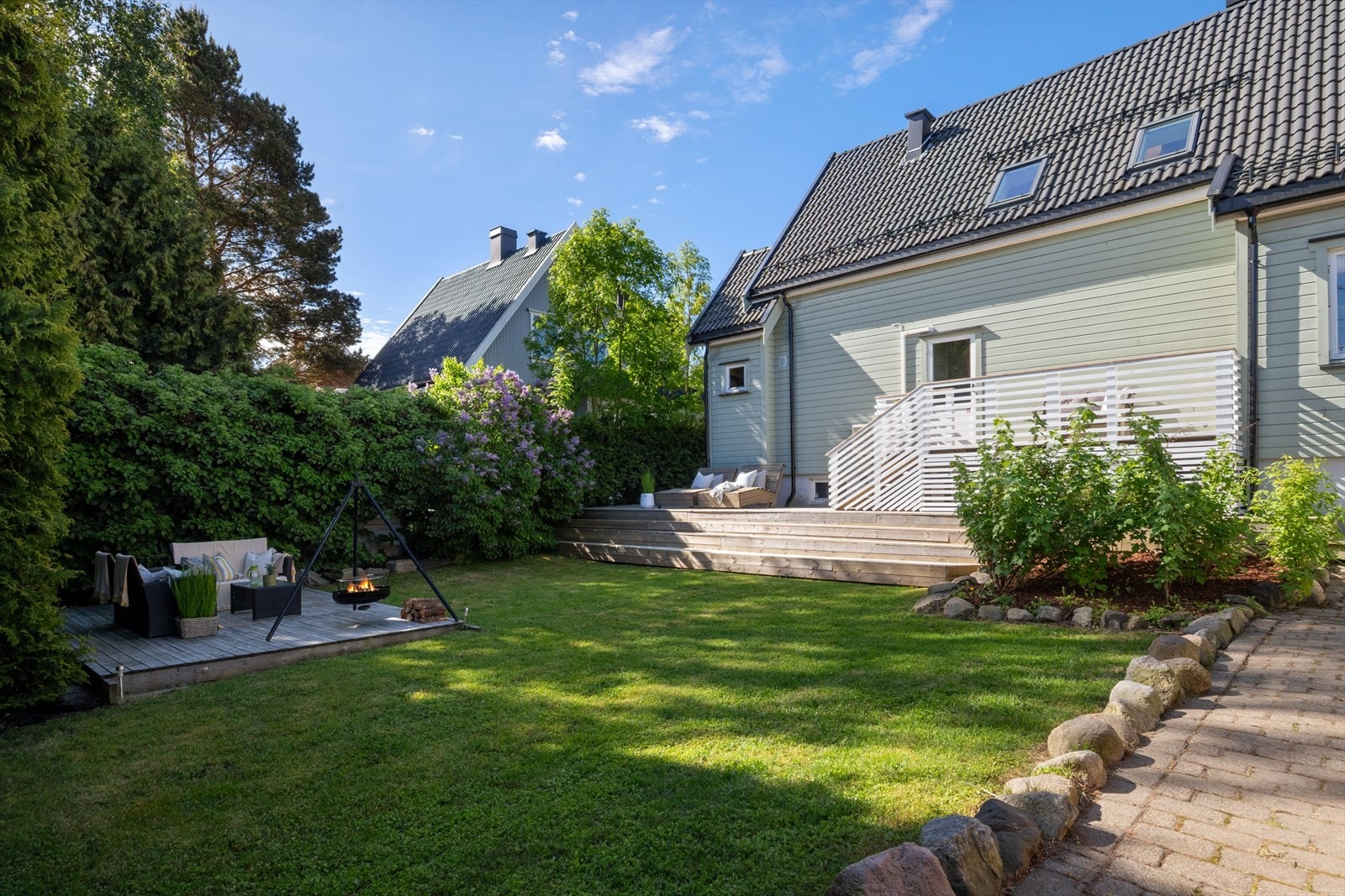 Hagen er pent opparbeidet med plen og beplantning som rammer inn eiendommen. Galleribilde