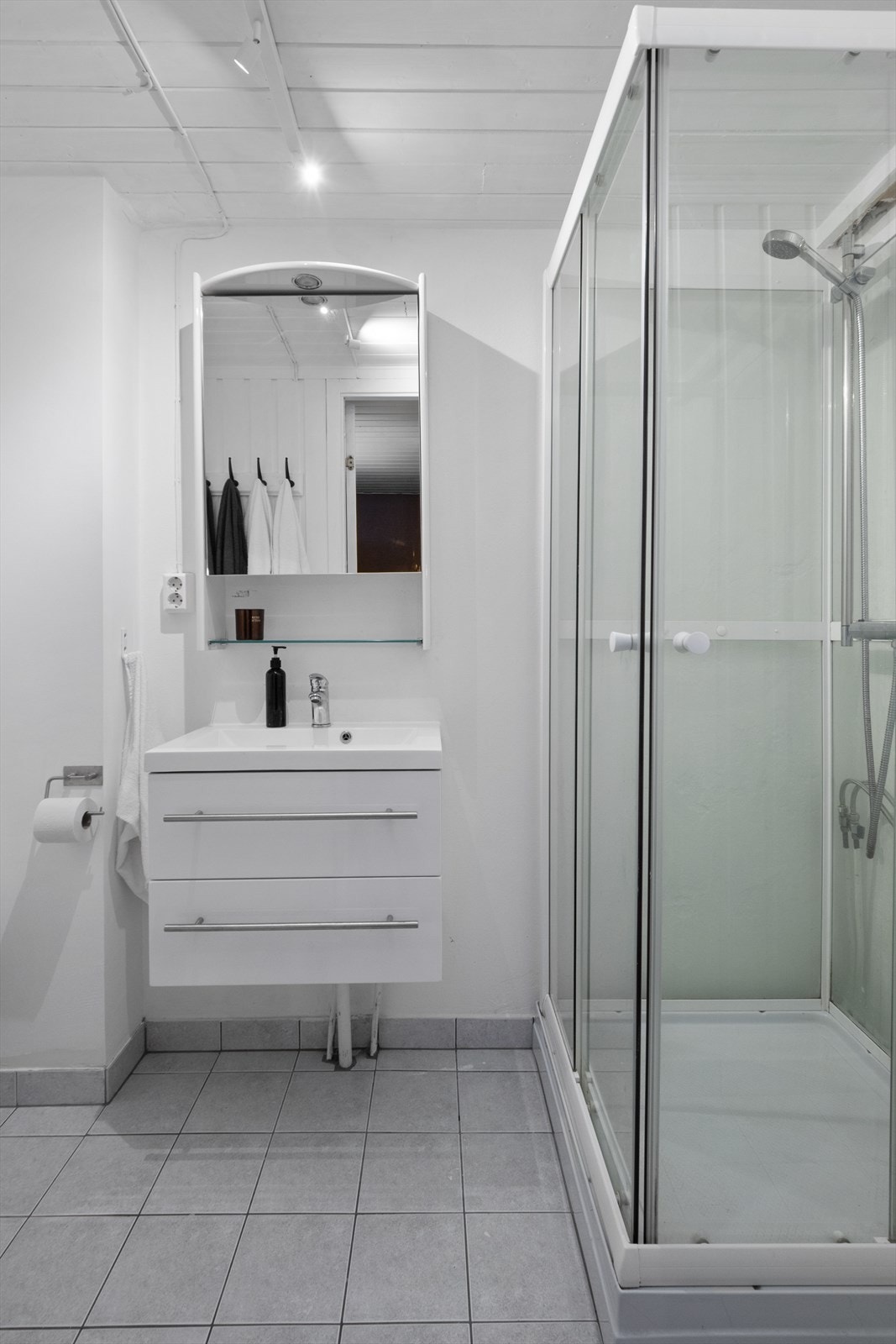 Badet er utstyrt med servantinnredning, toalett og dusjkabinett. Galleribilde