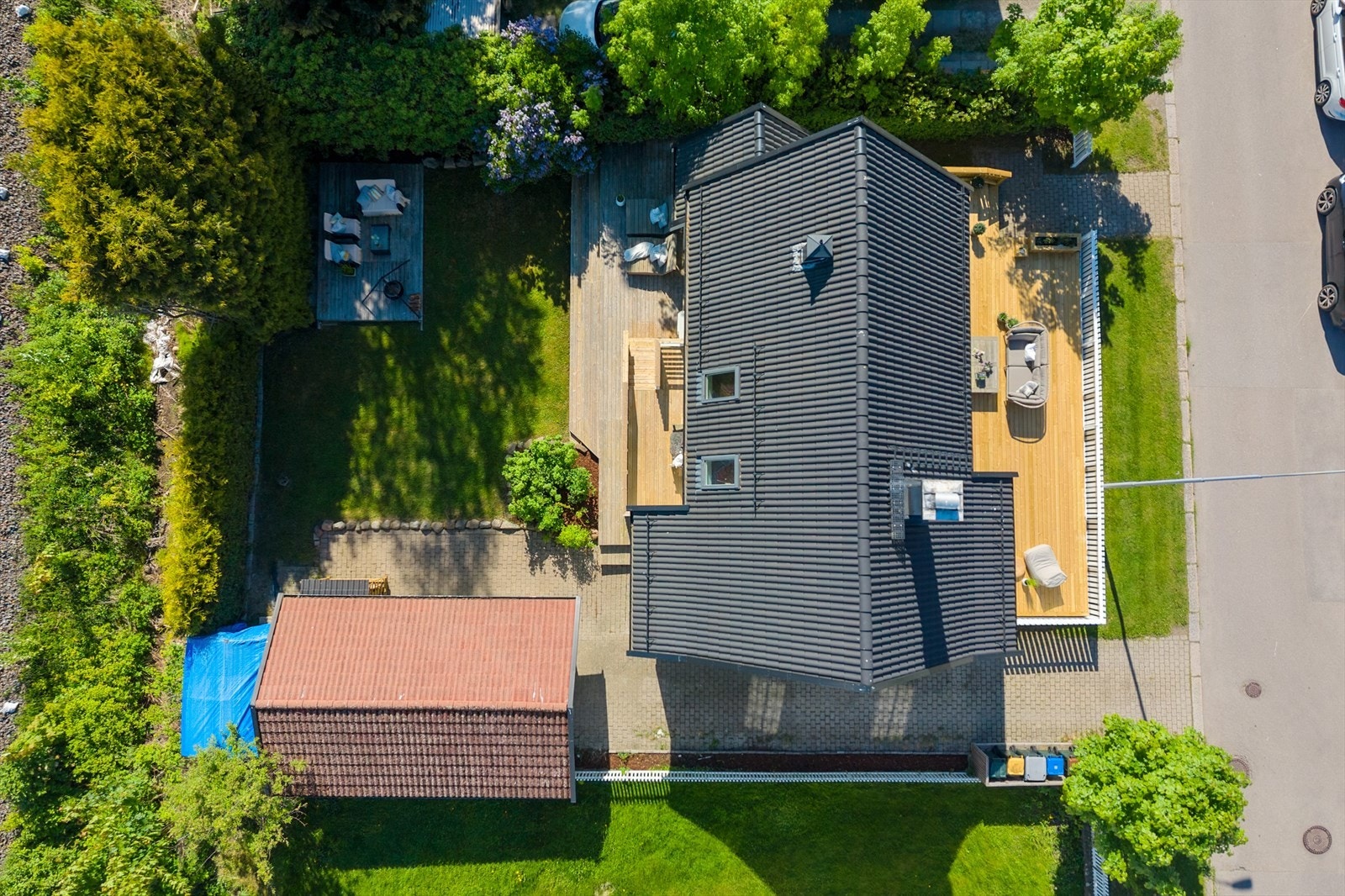 Oversiktsbilde som viser boligens plassering på tomten, med garasje og store terrassearealer. Galleribilde